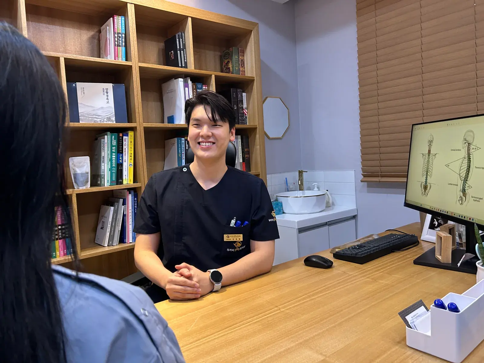 두꺼비365한의원 진료실 - 척추 모니터와 책장
